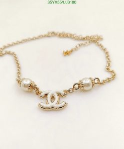 Gold chain bracelet with logo and pearl details.