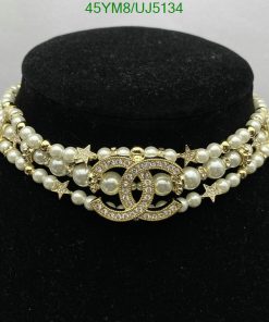 Pearl necklace with gold accents on black display.