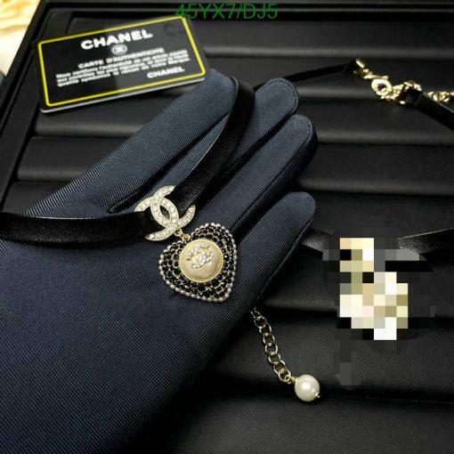 Elegant black clutch with branded pendant and authenticity card.