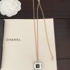 Chanel necklace on box with white flower decoration.