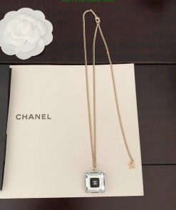 Chanel necklace on box with white flower decoration.