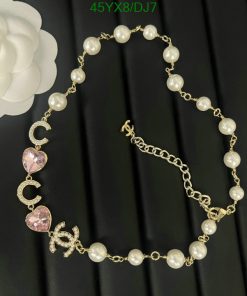 Pearl bracelet with gold chain and pink hearts.