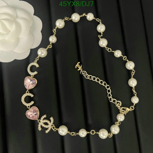 Pearl bracelet with gold chain and pink hearts.