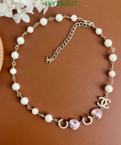 Elegant pearl necklace with pink gemstone and gold accents.