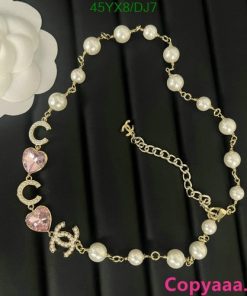 Pearl necklace with heart pendant on dark background.