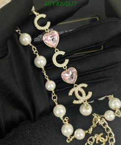 Elegant pearl and crystal charm bracelet on black glove.