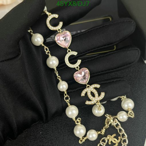 Elegant pearl and crystal charm bracelet on black glove.