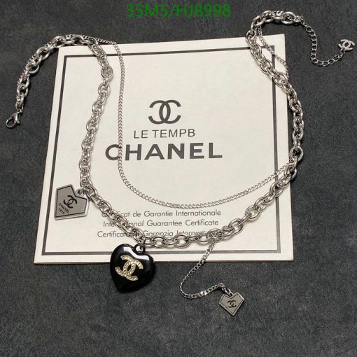 Chanel necklace with certificate on gray background.