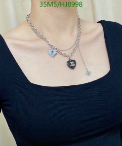 Woman wearing designer heart pendant necklace.