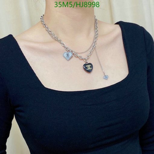 Woman wearing designer heart pendant necklace.