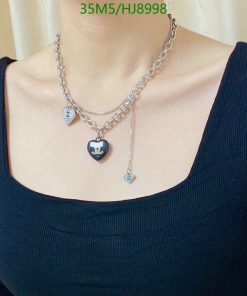 Woman wearing designer heart pendant necklace.