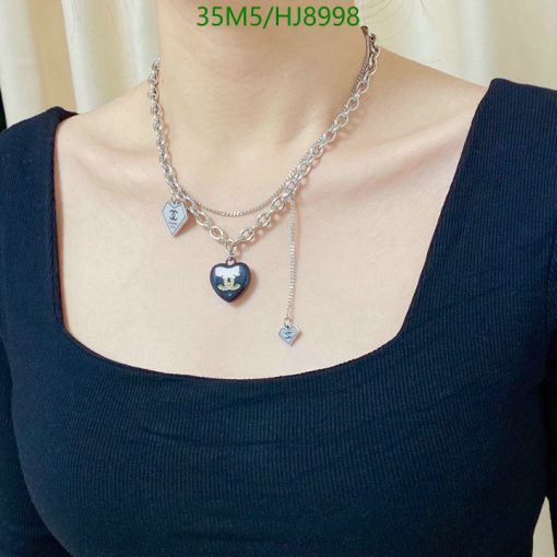 Woman wearing designer heart pendant necklace.