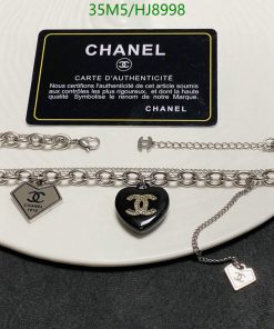 Chanel jewelry and authenticity card on white background