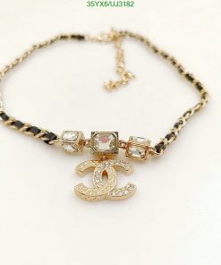 Gold charm bracelet with crystal accents on white background.