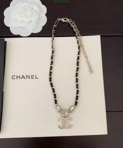 Chanel branded necklace with pendant on book.