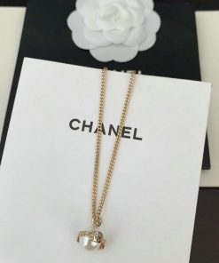 Gold necklace with pendant on branded display.