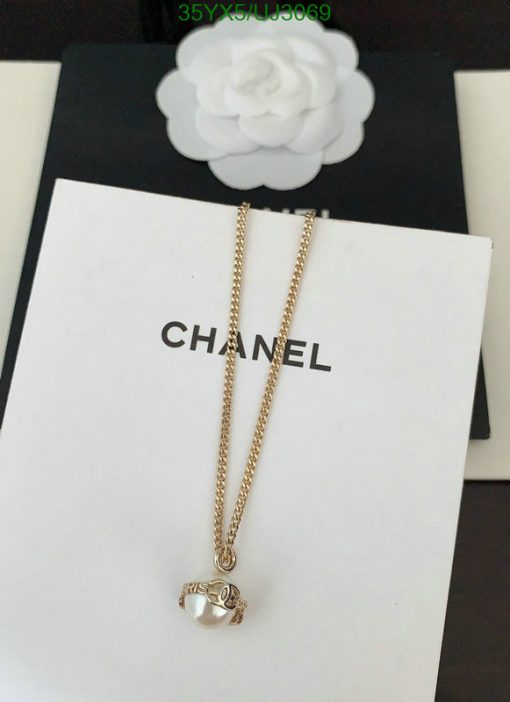 Gold necklace with pendant on branded display.