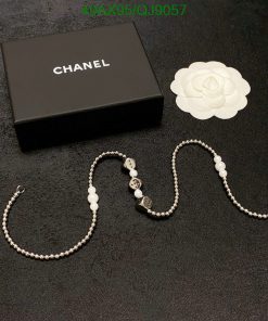 Chanel necklace with box and white flower decoration.