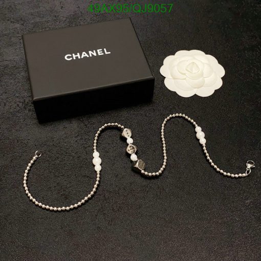 Chanel necklace with box and white flower decoration.