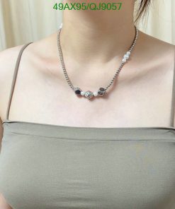 Woman wearing pearl and bead necklace.