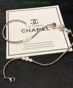 Chanel pearl bracelet with guarantee certificate on black background.