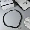 Elegant black beaded necklace with silver clasp and packaging.