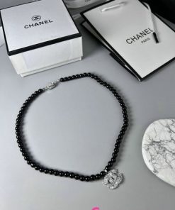 Elegant black beaded necklace with silver clasp and packaging.