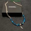 Designer blue bead necklace with silver chain on box.