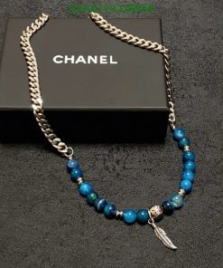 Designer blue bead necklace with silver chain on box.