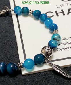 Blue beaded bracelet with feather charm and certificate.