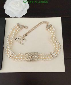 Pearl necklace on display with floral accent.