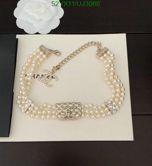 Pearl necklace on display with floral accent.