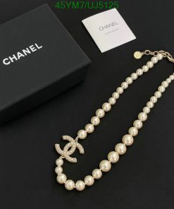 Pearl necklace with logo pendant beside box and card.