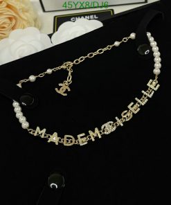 Gold Mademoiselle pearl necklace on black surface.