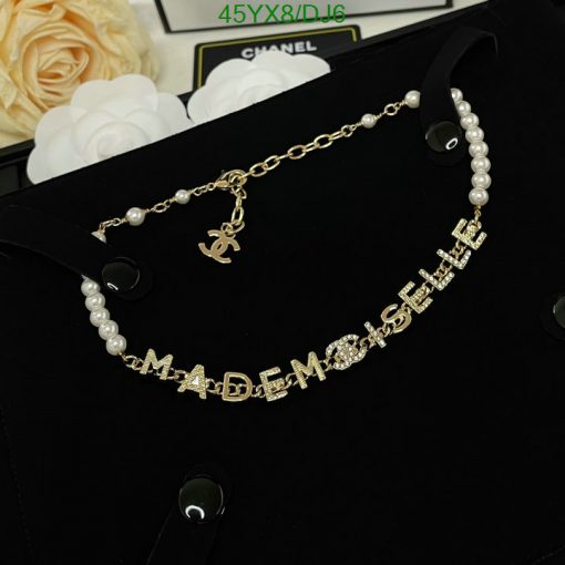 Gold Mademoiselle pearl necklace on black surface.