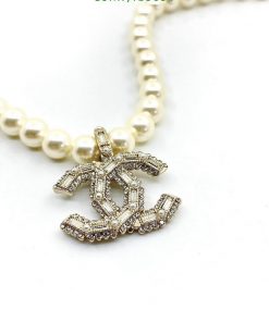 Pearl necklace with diamond-encrusted dollar sign pendant.