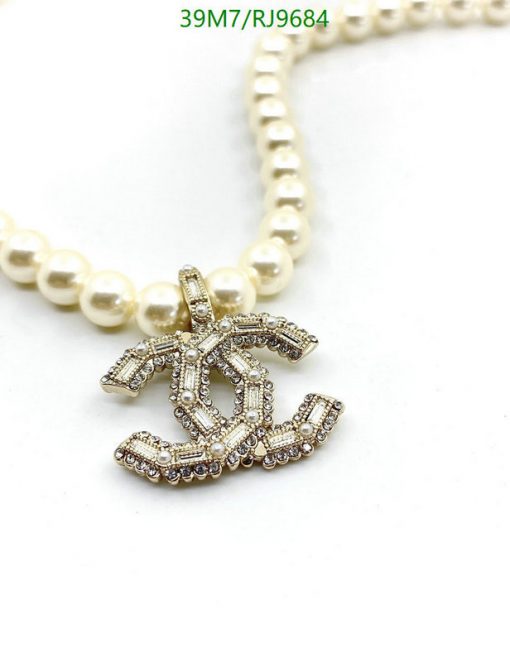 Pearl necklace with diamond-encrusted dollar sign pendant.