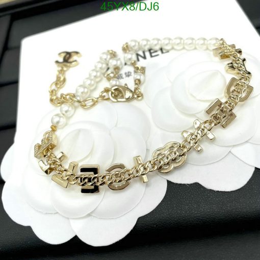 Designer gold chain bracelet with white floral detail.