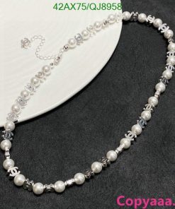 Elegant pearl and silver bead necklace on dark surface.