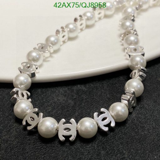 Pearl necklace with silver interlocking logo design elements.