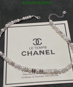 Elegant pearl necklace over Chanel certificate.