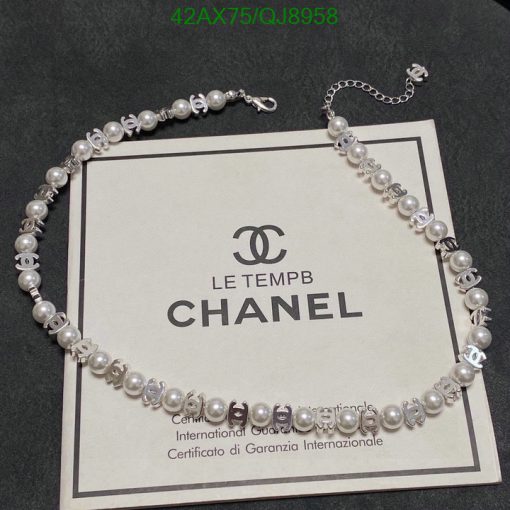 Elegant pearl necklace over Chanel certificate.