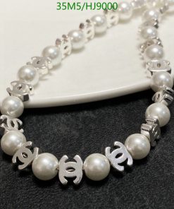 Pearl necklace with silver accents on white surface.