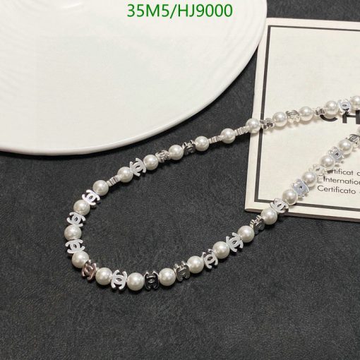 Pearl necklace with silver accents on dark background.