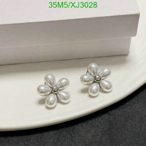 Pearl flower earrings with diamond accents on plate.