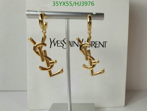 Gold designer logo earrings on display stand.