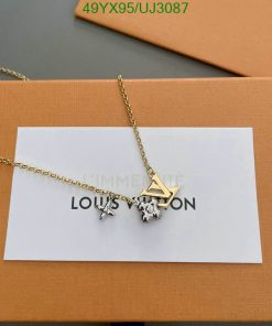 Gold chain necklace with charms and packaging.