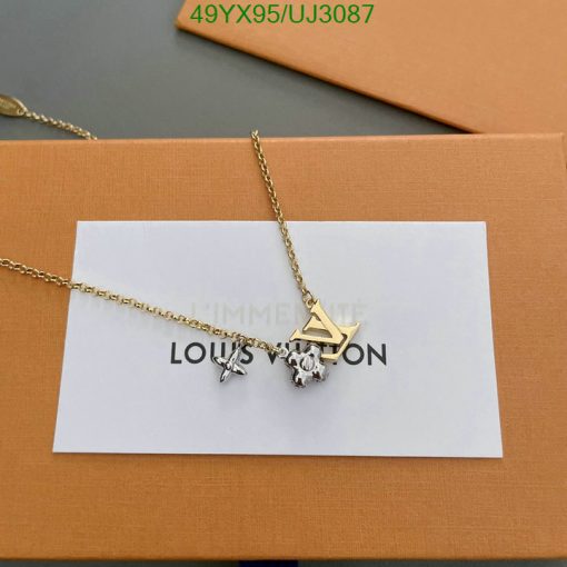 Gold chain necklace with charms and packaging.