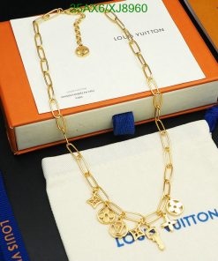 Gold charm necklace on packaging with brand logo.