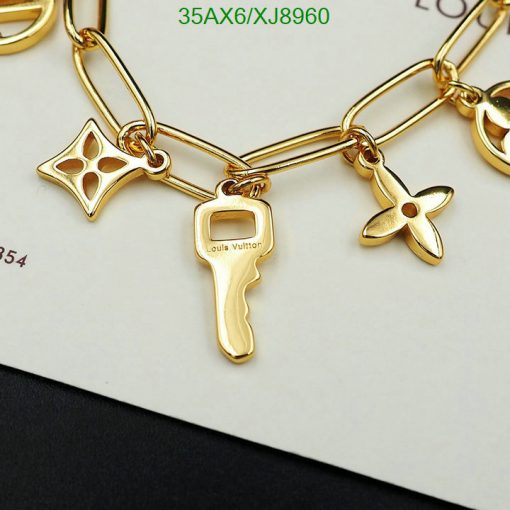 Gold charm bracelet with designer label and shapes.